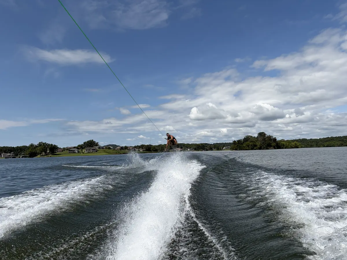 Wakeboarder carving across the water behind a boat